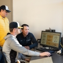 Dr. Rene Salinas, professor of Mathematical Sciences (left), with head coach of the baseball team, Kermit Smith and sophomore Cameron Lyons talk stats looking at Trackman data from the previous game. Photo by Ellen Gwin Burnette