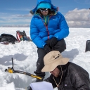 On top of the Quelccaya Ice Cap, junior geography major Cole Barrow, bottom right, relays measurements from a snow pit to senior geography major Michael Godwin, far left, and John Howarth, who played a supporting role during the expedition. Photo by Marie Freeman