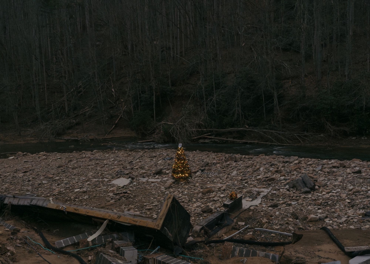 A Christmas tree stands in the rubble where Kim and Rod Ashby’s home once stood along the Elk River near Elk Park. Kim and Rod were separated in the floodwaters the day of the flood with Rod escaping to the bank a few miles down river. Kim has yet to be found. Photo by Barber (jesse-barber.com)