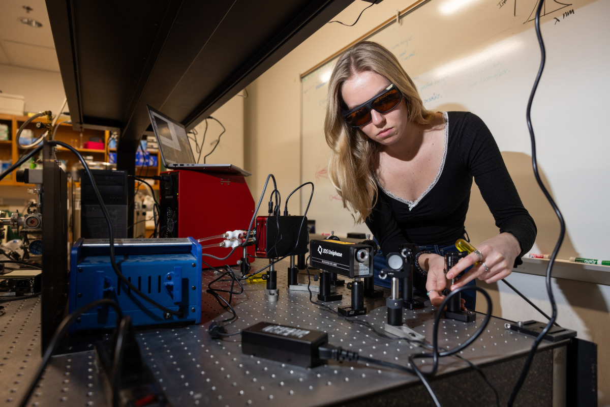 Junior physics major Chloe Thompson, of Mooresville, adjusts the laser pathway for the spatial light modulator. Photo by Chase Reynolds
