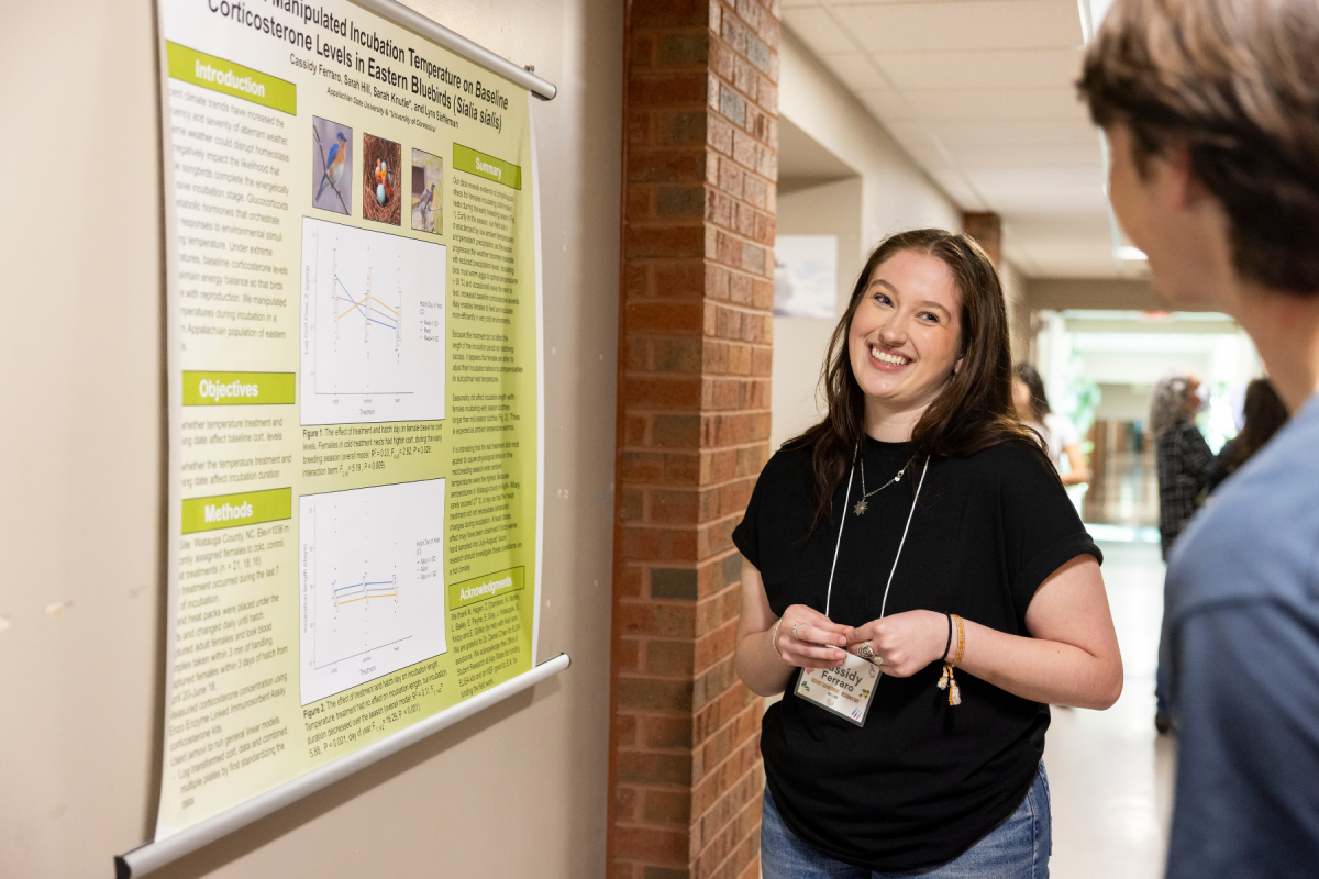 Cassidy Ferraro, a sophomore in biology, discusses her research on the effects of temperature fluctuations on nesting eastern bluebirds. Photo by Kyla Willoughby