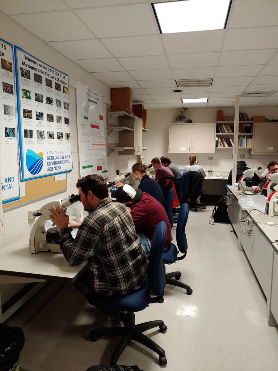 Geology students in the lab viewing lunar surface samples from NASA