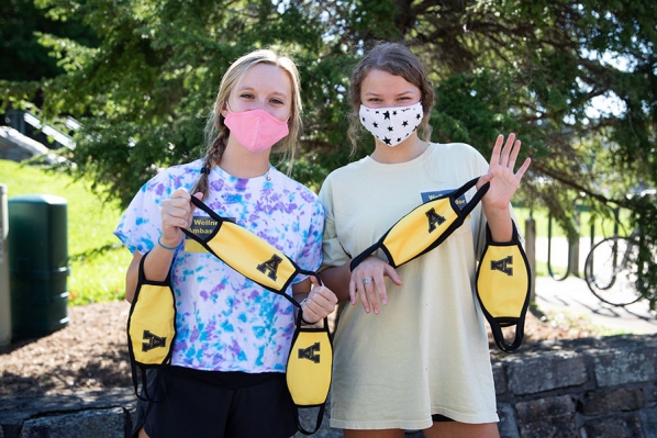 During fall 2020, Appalachian State University students developed and supported peer accountability programs to encourage members of the Appalachian Community to comply with safety precautions related to COVID-19. Pictured are Wellness Ambassadors Melina Tirrell, left, a sophomore social work major from Pineville, and Jessica Phillips, a sophomore finance and banking major from Charlotte, handing out face coverings. Photo by Chase Reynolds