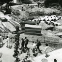 Students walk by a fence positioned around the site of the former College Bookstore, built in 1934, at Appalachian State Teachers College (1929–1967) after its demolition in 1967. The Education Building, built in 1925, can be seen in the background. In addition to renting and selling textbooks, the College Bookstore also provided Appalachian merchandise, supplies and refreshments, while the second floor provided space for three apartments. A snack bar was added in 1955. In 1967, the building was demolished 