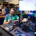Dr. Zachary Russell, assistant professor in the Department of Physics and Astronomy at App State, center, works with student researchers Ethan Humphries, a senior in physics major from Kings Mountain, and Hunter Corman ’24, an engineering physics graduate student from Morehead City, pictured in the background, in the Ion Innovations Scientific Instrumentation Development Lab in Boone to assemble 3D-printed components for rapid prototyping of microscope designs. Russell has been awarded a $2.3 million grant