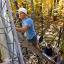 Dr. James Sherman, professor in App State’s Department of Physics and Astronomy, checks cables and connections on the Appalachian Atmospheric Interdisciplinary Research (AppalAIR) tower while Ethan Barber ’22, an engineering physics graduate student from Durham, center, and Shawn Beekman ’22, an engineering physics graduate student from Cary, far right, hold the ladder below. Sherman, Barber and Beekman are part of the research team that received a three-year, $531,902 grant from the National Science Founda