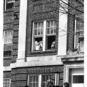 This image shows students standing outside the Watauga Residence Hall, built 1929, at Appalachian State University (1967-current) in the 1970s. Two students can be seen sitting in the second floor window. (University Archives)
