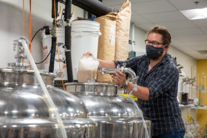 Daniel Parker, operations manager for the fermentation facility and lecturer in the Department of Chemistry and Fermentation Sciences, pitching the yeast into the fermentation tank. Photo by Ellen Gwin Burnette.