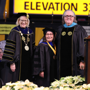 During App State’s 9 a.m. Fall 2023 Commencement ceremony on Dec. 15, Dr. Maryam Ahmed, professor of viral pathogenesis and immunity in the Department of Biology, center, is presented with the 2023 University of North Carolina Board of Governors Excellence in Teaching Award. She is pictured with App State Chancellor Sheri Everts, left, and UNC Board of Governors member C. Philip Byers. Photo by Chase Reynolds