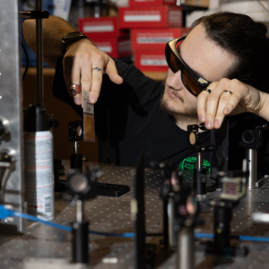 A man wearing goggles holds a card in front of a sensor.
