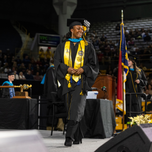 Appalachian Police Department Master Police Officer Cashae Cook ’14 ’25 — who is now a two-time alumna of App State — crosses the commencement stage to earn her Master of Public Administration during the university’s Fall 2025 Commencement, held Dec. 12 in Holmes Convocation Center on the Boone campus. Cook holds a bachelor’s degree in criminal justice and a graduate certificate in nonprofit administration, both from App State. Photo by Chase Reynolds