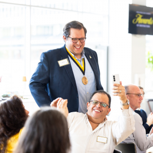 App State senior Juan Pablo “J.P.” Neri stands to be recognized at App State’s 2025 Awards of Distinction ceremony, held April 24 on the Boone campus. Neri’s father, Eduardo, sits in front of him, capturing the moment with a selfie. Neri is a recipient of the 2025 W.H. Plemmons Leadership Medallion. Photo by Kyla Willoughby