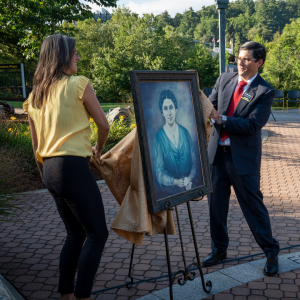 Dr. Paul Worley, professor in and chair of App State’s Department of Languages, Literatures and Cultures, right in foreground, and Andrea Elaver, assistant director of university events, unveil the rededicated portrait of Lillie Shull Dougherty — one of App State’s three founders — during the 2023 Founders Day ceremony at Founders Plaza. Photo by Troy Tuttle