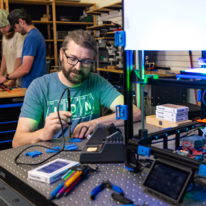 Dr. Zachary Russell, assistant professor in the Department of Physics and Astronomy at App State, center, works with student researchers Ethan Humphries, a senior physics major from Kings Mountain, and Hunter Corman ’24, an engineering physics graduate student from Morehead City, pictured in the background, in the Ion Innovations Scientific Instrumentation Development Lab in Boone to assemble 3D-printed components for rapid prototyping of microscope designs. Russell has been awarded a $2.3 million grant fro
