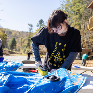 In the wake of Hurricane Helene, App State students rallied to help their High Country neighbors — from daring rescues and digging out trapped residents to volunteering with storm cleanup and repairs. Above, students volunteer with cleanup at an area river outfitter during a Day of Service on Oct. 19, 2024. That day, around 175 students collectively completed over 500 hours of community service at 15 organizations and locations across the High Country. Photo by Kyla Willoughby