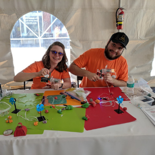 Dr. Leah Sherman, director of undergraduate laboratories, Department of Physics and Astronomy, and senior Trae Jenks showing squishy circuits at the PandA Booth at Gravity Games held in Lenoir, N.C. Photo submitted.