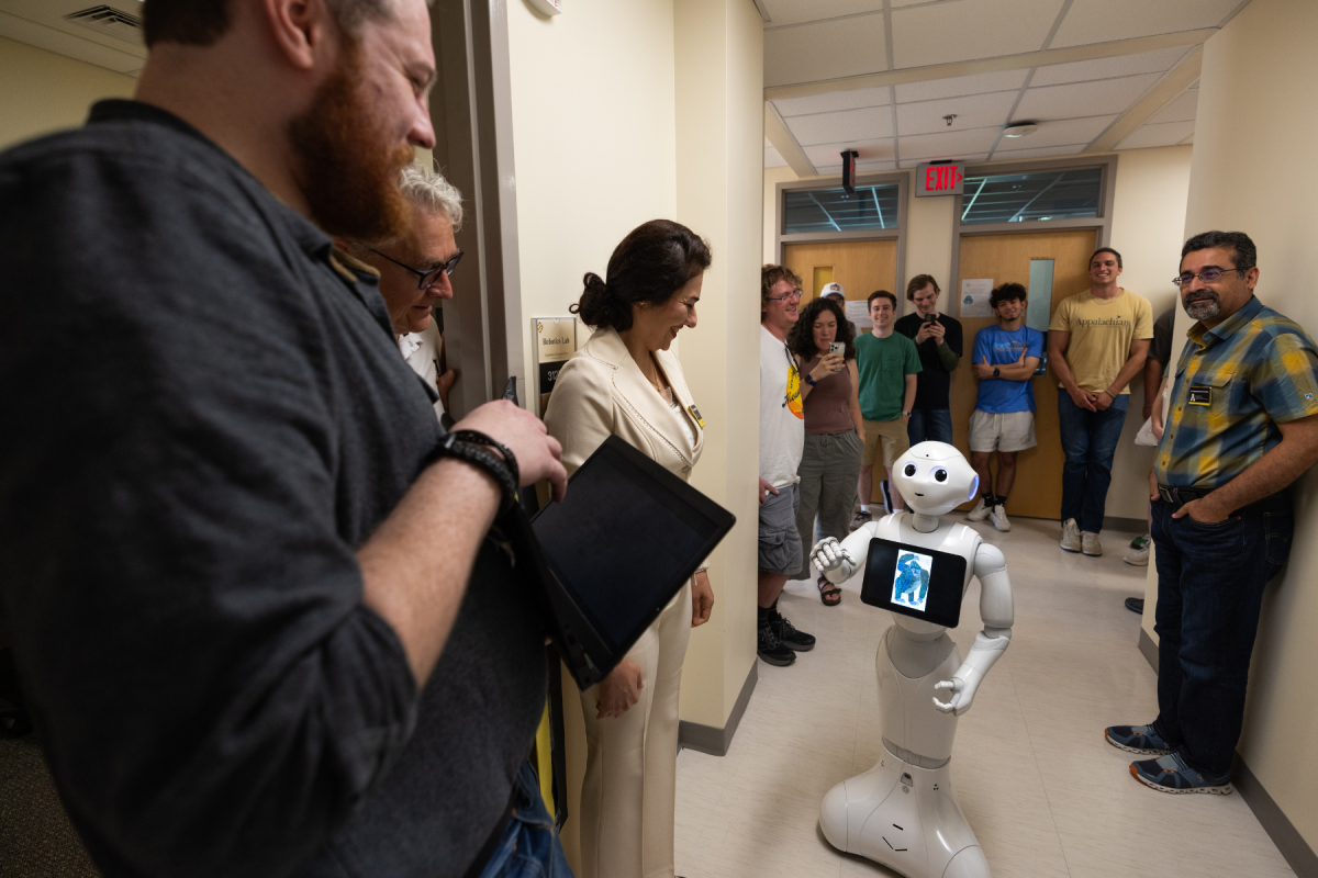 Zach Carter ’24 (left), a graduate student in the Computer Science program, and Dr. Yeganeh Madadi, assistant professor in the Department of Computer Science and director of the Robotics Lab, demonstrate how YeRo, a humanoid robot, can assist children with their communication skills. Photo by Chase Reynolds